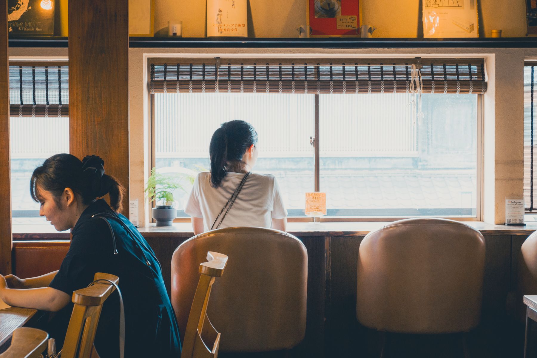 窓際の席が並ぶ、木の質感を残した喫茶店の店内